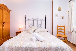 Une chambre à coucher avec un lit, une armoire en bois et une chaise.