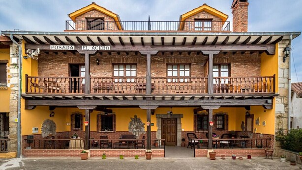 A two-story building with a sign reading "POSADA EL ACEBO".