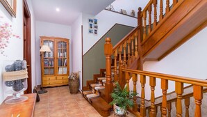 A staircase with wooden balusters and a handrail, leading to an upper floor.