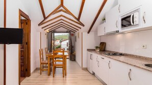 A modern kitchen with white cabinets, a granite countertop, and a built-in microwave. - San Telmo estudio - beach and nature (Ubiarco)
