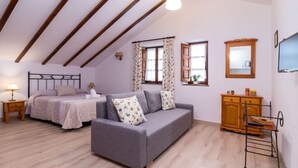 A bedroom with a bed, a sofa, a wooden dresser, and a television. - San Telmo estudio - beach and nature (Ubiarco)