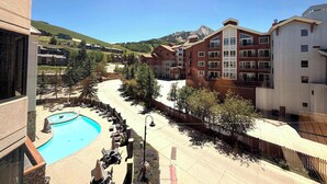 Um hotel com piscina, área de estar ao ar livre e vista para as montanhas.