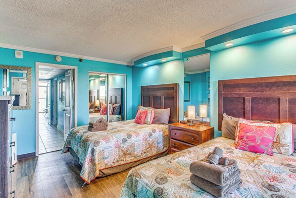 A hotel room with two beds, a wooden headboard, a nightstand, and a mirror. - Sun, Sand & Sea Views: Myrtle Beach Condo (Myrtle Beach)