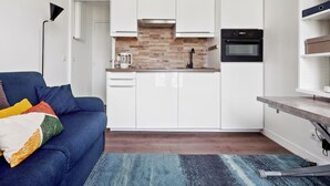A modern kitchen with white cabinets, a built-in oven, and a coffee maker.