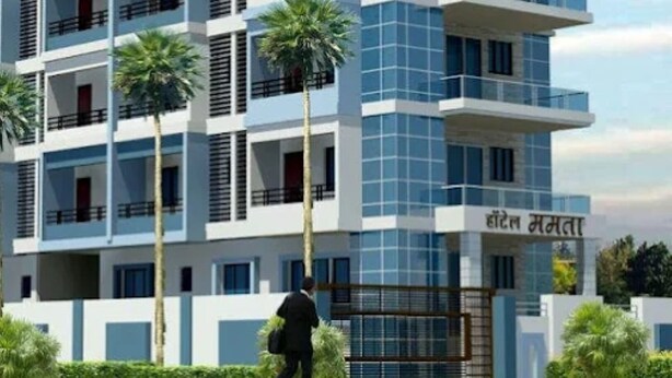 Ένα πολυώροφο ξενοδοχείο με μοντέρνο σχεδιασμό, που διαθέτει μπαλκόνια και μια επιγραφή σε μη λατινικό αλφάβητο.