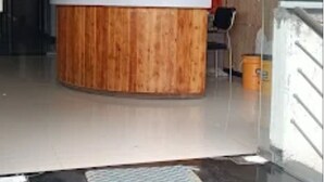 Ένας χώρος υποδοχής με έναν ξύλινο πάγκο, έναν ανεμιστήρα οροφής και έναν πίνακα κρεμασμένο στον τοίχο.