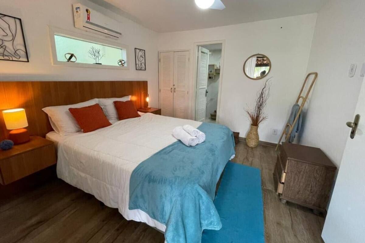 Ein Schlafzimmer mit Bett, Nachttisch, Lampe und Deckenventilator.