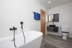 A modern bathroom with a freestanding bathtub, a toilet, and a vanity with a mirror. - New 19m Eco Pool Villa Sunset Garden 10 (Rawai)