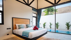 A modern bedroom with a large bed, a view of a swimming pool, and a balcony with plants. - New 19m Eco Pool Villa Sunset Garden 10 (Rawai)