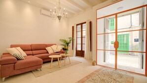 A living room with a sofa, a small table, and a chandelier.