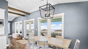 A modern kitchen with white cabinets, a wooden countertop, and a hanging light fixture.