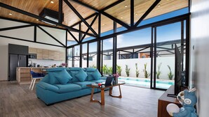 A modern living room with a blue sofa, wooden coffee table, and a pool view. - 17m Oxygen Pool Villa Sunset Garden 11 (Rawai)