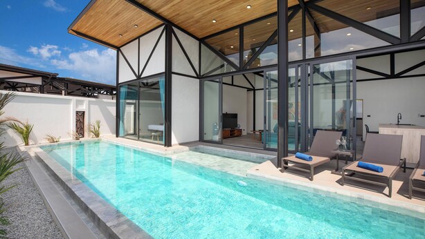 A modern pool area with clear blue water, lounge chairs, and a wooden ceiling structure. - 17m Oxygen Pool Villa Sunset Garden 11 (Rawai)