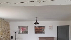A room with a bed, a dresser, a lamp, and a wall with pictures.