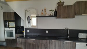 A modern kitchen with wooden cabinets, a microwave, an oven, a sink, and a toaster.