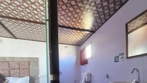 A hotel room with a bed, a toilet, and a sink. - Crane Valley Cottage (Leh)