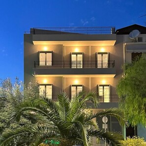 A multi-story building with balconies and windows, surrounded by greenery. - Suite No1 (Rethymno)