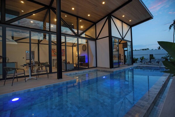 Una piscina al aire libre, sillones reclinables de piscina
