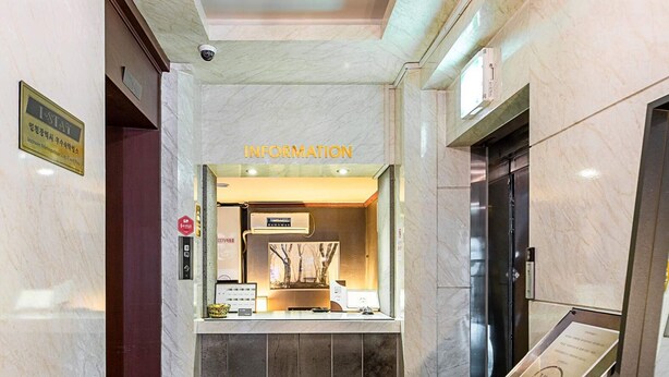 A hotel lobby with a marble floor, an information desk, and a security camera. - HOTEL JUNO (Incheon)
