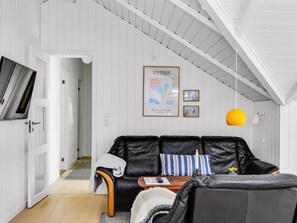 A modern living room with a black leather sofa, a wooden coffee table, and a yellow pendant light. - "Mila" - 30km from the sea by Interhome (Toftlund)