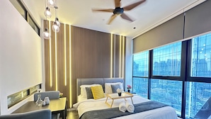 A modern hotel room with a large bed, a desk, and a view of the city. - Scarletz Suites KLCC by Purple Orchid (Kuala Lumpur)