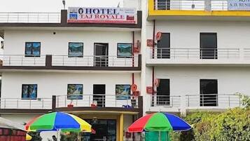 A hotel with a sign reading "HOTEL LA ROYALE" and balconies with railings.