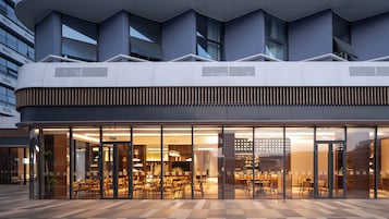 Un edificio moderno con fachada de vidrio, techo plano y varias ventanas.