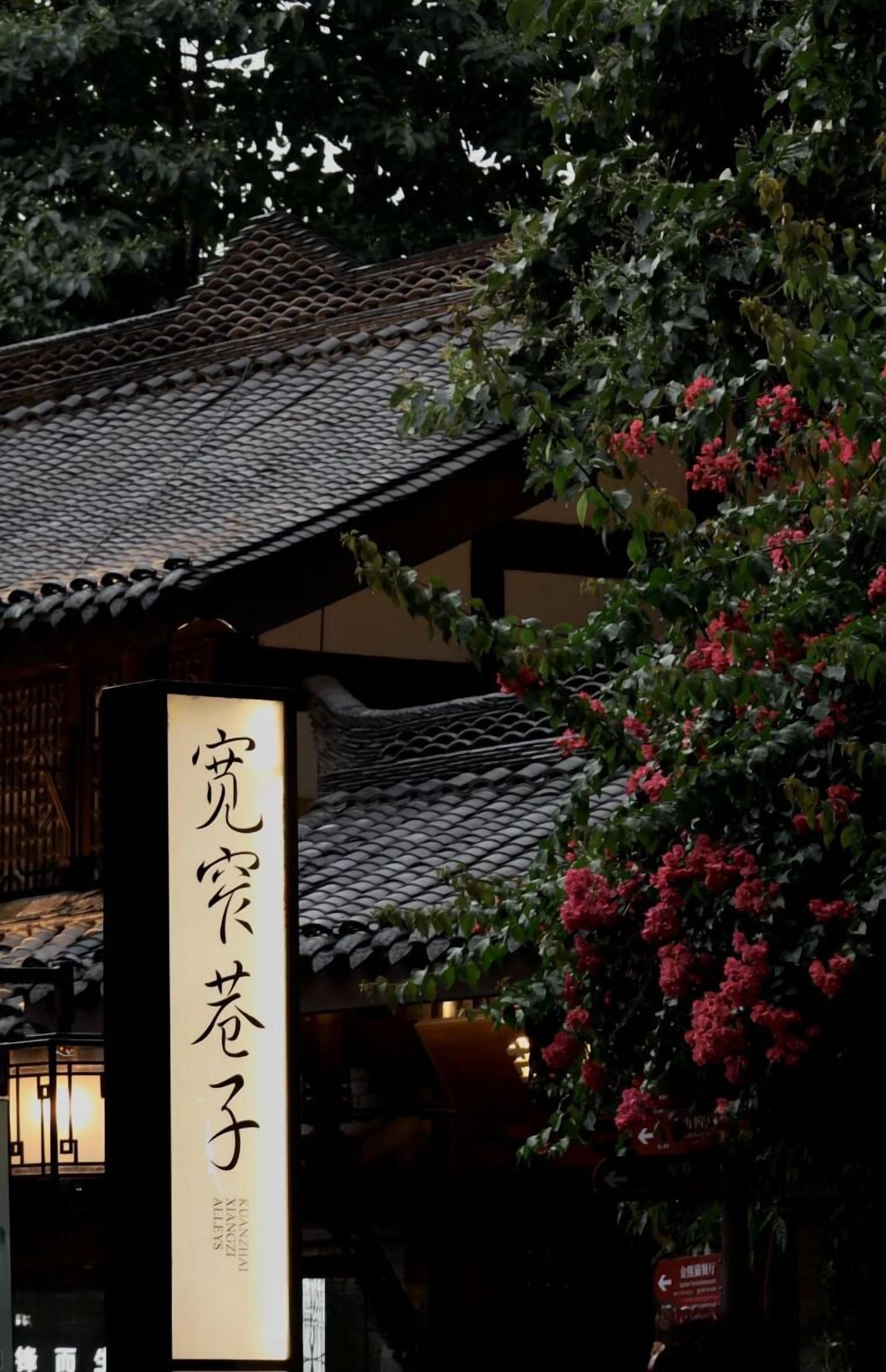 A traditional Japanese building with a tiled roof and a sign with Japanese characters.