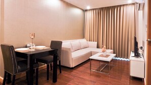 Uma sala de estar moderna com uma mesa de jantar, sofá e uma pequena mesa de centro.