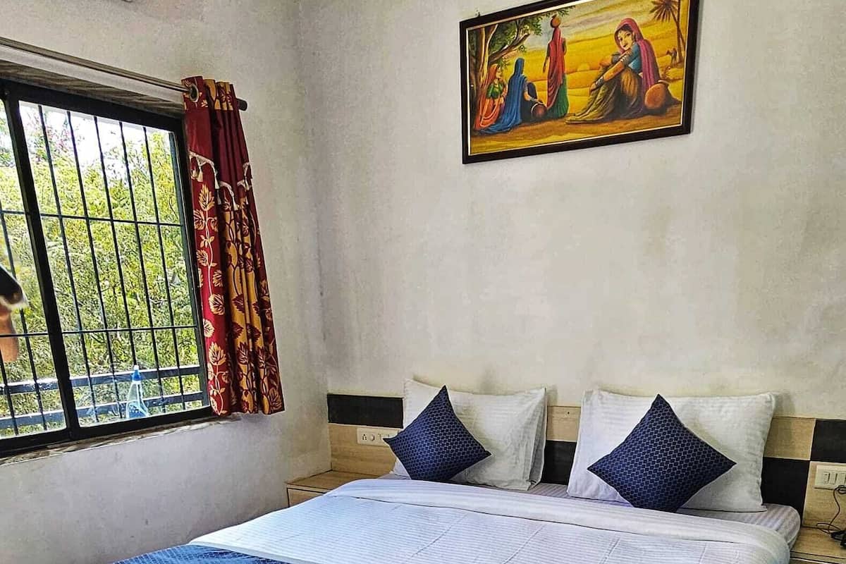 Une chambre à coucher avec un lit, une fenêtre avec des rideaux et un tableau accroché au mur.