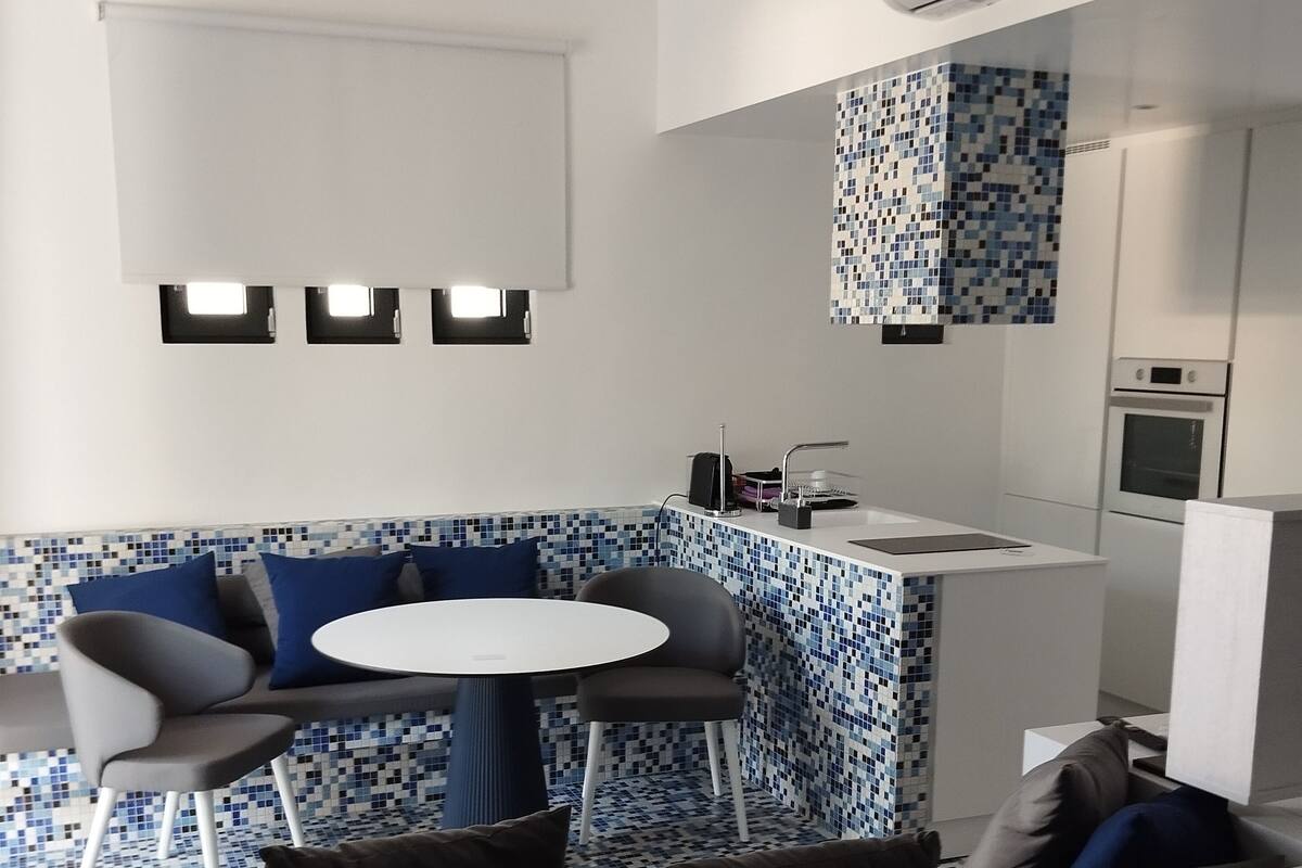 A modern kitchen with a white countertop, a built-in oven, and a tiled backsplash.
