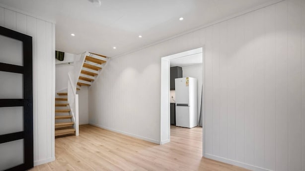 A hallway with wooden flooring, white walls, and a staircase with wooden steps. - Large Single-family Home - Central in Voss (Voss)
