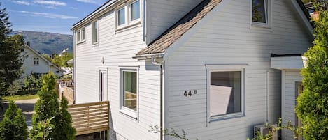 Une maison à deux étages, avec le numéro « 44B » affiché sur la façade.