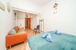 A bedroom with a bed, a chair, a sofa, and a door leading to another room. - 4-bed Villa, Sleeps 8, Pets Ok & 10 min to Beach (Los Alcazares)