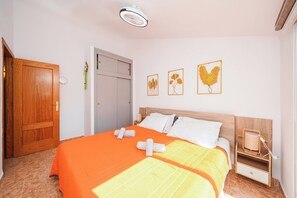 A bedroom with a bed, a bedside table, a nightstand, a door, and wall art. - 4-bed Villa, Sleeps 8, Pets Ok & 10 min to Beach (Los Alcazares)
