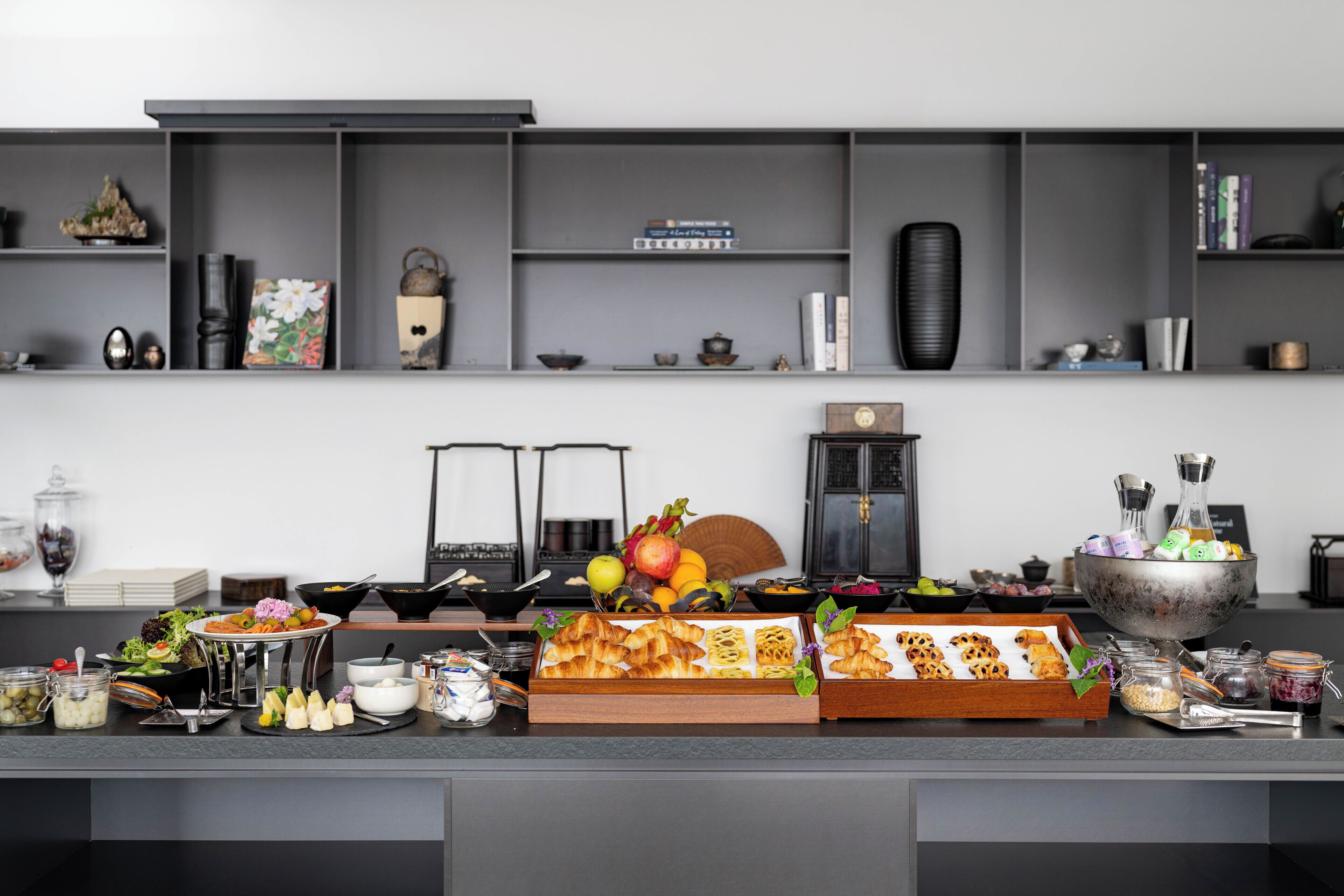 A buffet setup with various food items and a coffee machine.