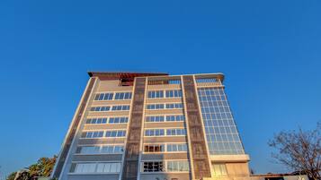 Un edificio alto y moderno con varios pisos y ventanas grandes.