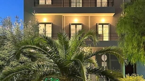 A multi-story building with balconies and windows, surrounded by greenery. - Main Suite (Rethymno)