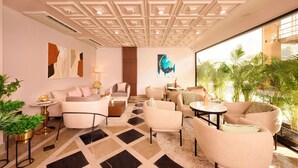 A modern hotel lobby with a geometric patterned floor, contemporary furniture, and a large window offering a view of greenery. - Iris Sarovar Portico Sector 85 Gurugram (Gurugram)