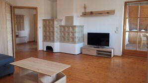 Un salon avec un téléviseur, un meuble en bois et un canapé.