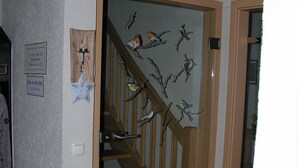 A staircase with a wooden handrail and a wall decorated with bird silhouettes. - Auenweg Apartment with Shared Pool, Garden, and Wi-Fi (Radebeul)