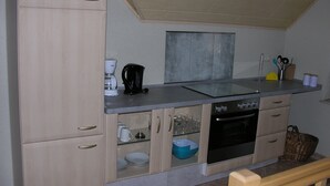 A kitchen with a dishwasher, oven, and coffee maker. - Auenweg Apartment with Shared Pool, Garden, and Wi-Fi (Radebeul)