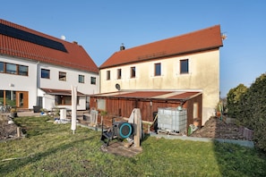 A residential building with a red-tiled roof, a covered garage, and a satellite dish.