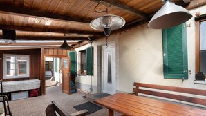 Interior de madera con un banco, una mesa y un ventilador de techo.