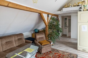 A living room with a sofa, armchair, glass coffee table, and a red patterned rug. - Apartment 'A Casa Alfred Kemmern - Neu' with Shared Terrace, Wi-Fi and Air Conditioning (Kemmern)