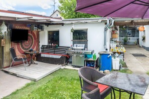 A backyard with a barbecue grill, a table, and a chair. - Apartment 'A Casa Alfred Kemmern - Neu' with Shared Terrace, Wi-Fi and Air Conditioning (Kemmern)