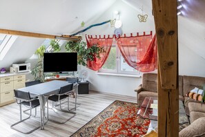 A modern loft-style room with a dining area, a sofa, and a TV. - Apartment 'A Casa Alfred Kemmern - Neu' with Shared Terrace, Wi-Fi and Air Conditioning (Kemmern)