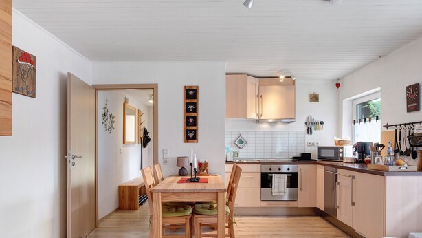Una cocina moderna con armarios de madera, una mesa de comedor con sillas y una isla de cocina.