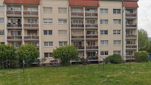 A multi-story residential building with balconies, a flat roof, and a grassy area in front. - Apartment 'Mücheln 2' with Balcony and Wi-Fi (Mücheln (Geiseltal))