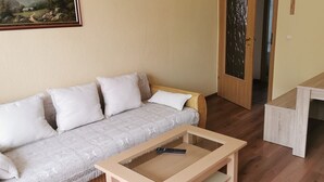 A room with a sofa, a small table, and a door with a frosted glass panel. - Apartment 'Mücheln 2' with Balcony and Wi-Fi (Mücheln (Geiseltal))